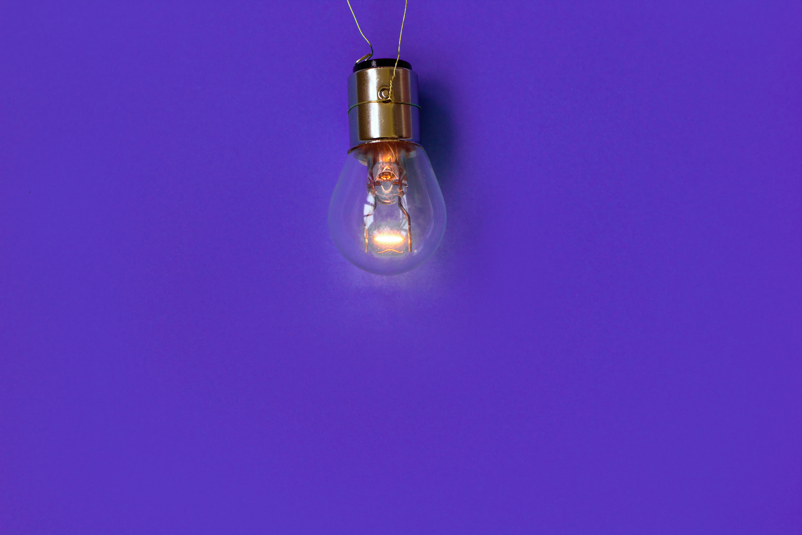 Glowing light bulb on a purple background